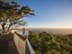 Two people at Mt Archer watching the sun set over the beautiful open views of the region